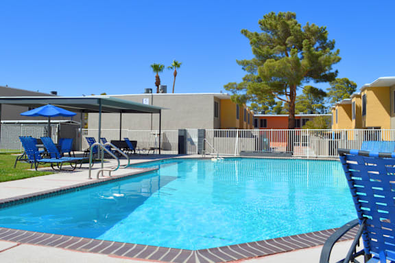 a swimming pool at a resort with chairs and umbrellas