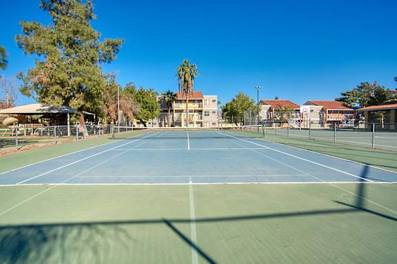 A tennis court with a blue sky in the background.