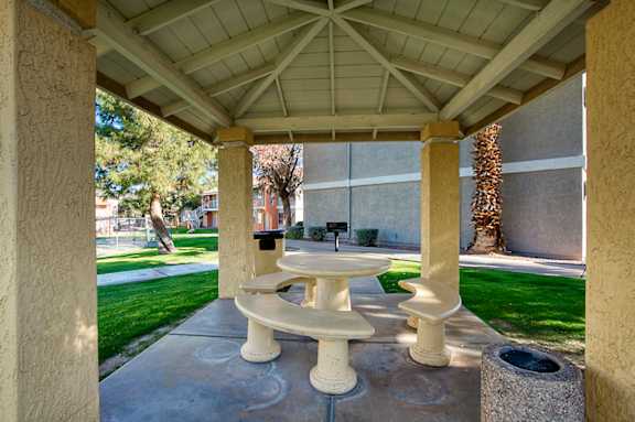 A white pedestal sink is in the middle of a concrete patio.