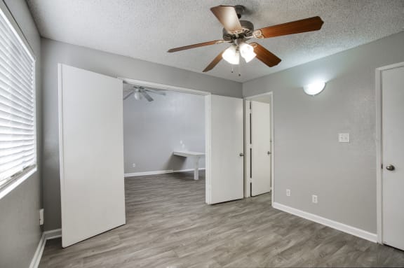a bedroom with a ceiling fan and a closet
