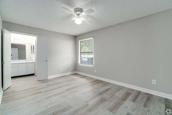 an empty living room with a ceiling fan and a window