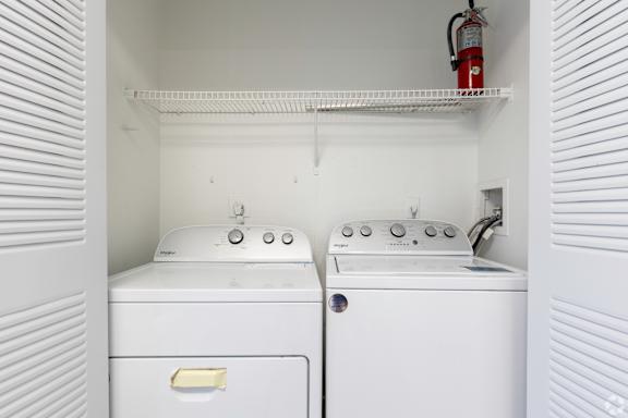an empty laundry room with two washes and a dryer