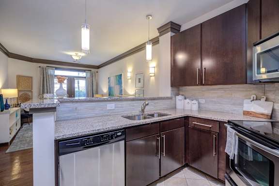 A kitchen with dark brown cabinets and a white counter.