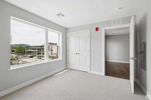 A room with a large window overlooking a parking lot.