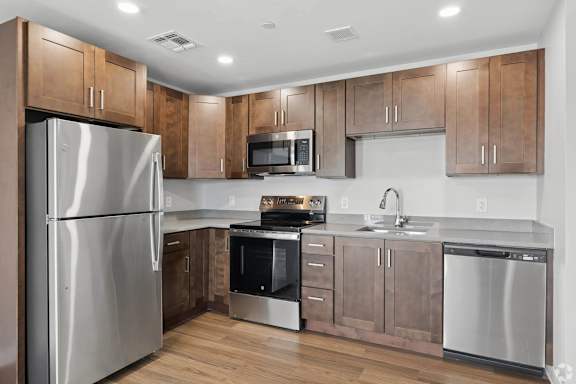 A modern kitchen with wooden cabinets and stainless steel appliances.