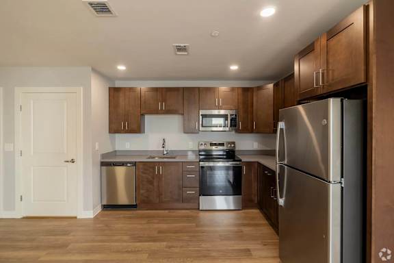 A modern kitchen with wooden cabinets and stainless steel appliances.