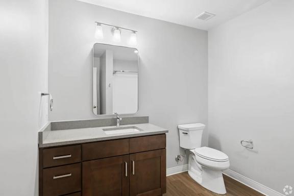 A white toilet sits next to a sink in a bathroom.