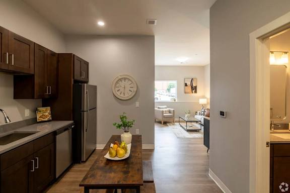 A kitchen with a wooden table and a clock on the wall.