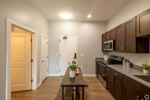 A kitchen with brown cabinets and a wooden table.