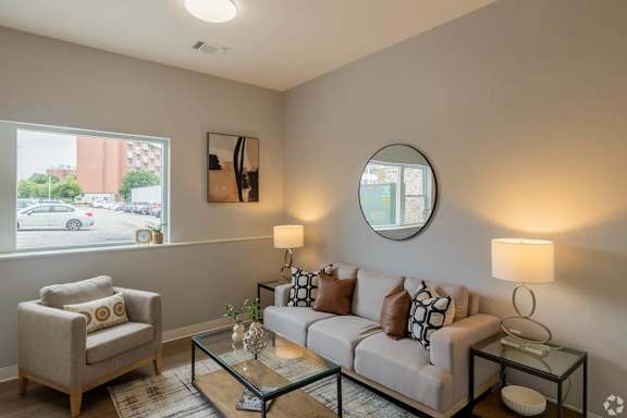 A living room with a couch, chair, and two lamps.
