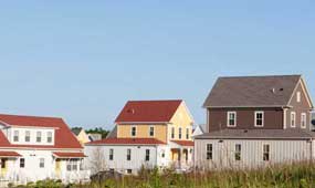 A row of houses with different colored roofs.