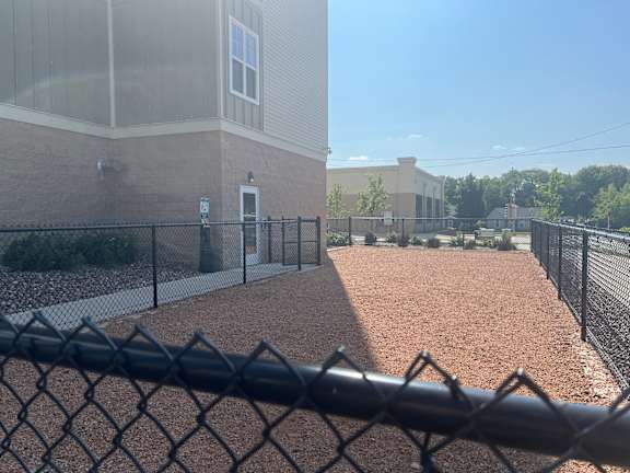 a chain link fence in front of a building with a dog run