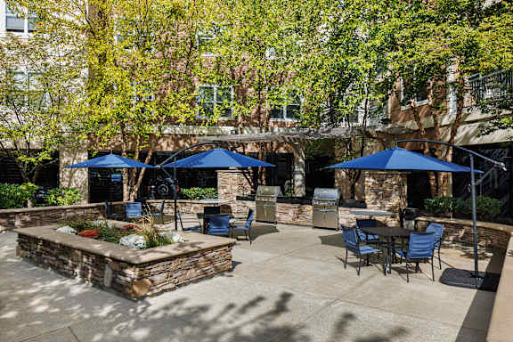 A patio with tables and chairs and umbrellas.