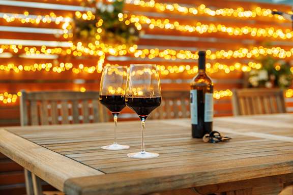 Two glasses of wine and a bottle on a table.
