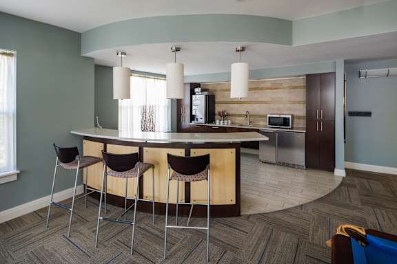 A kitchen with a bar area and chairs.