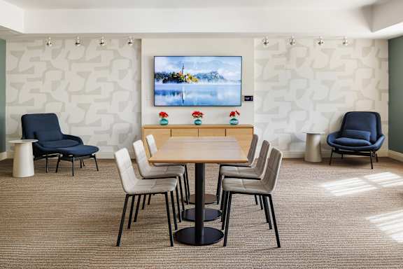 A conference room with a large screen and chairs.