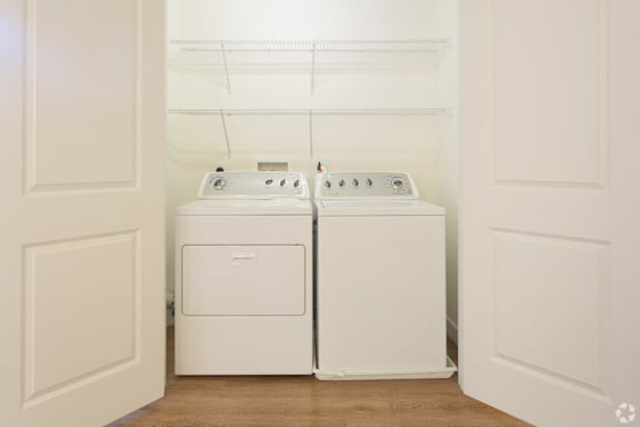 A white laundry room with a washer and dryer.