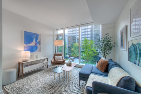 a living room with a large window and a blue couch