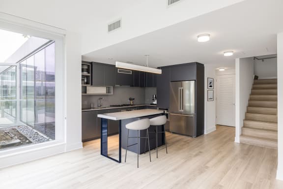 a kitchen with an island and stools in a 555 waverly unit