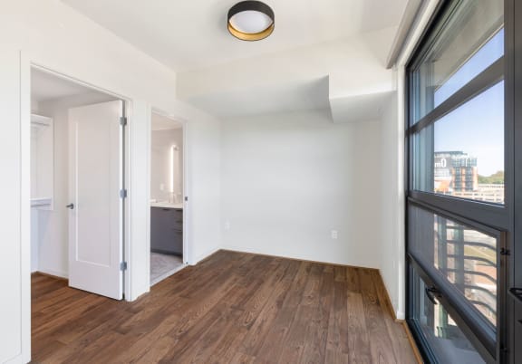 a bedroom with hardwood floors and white walls