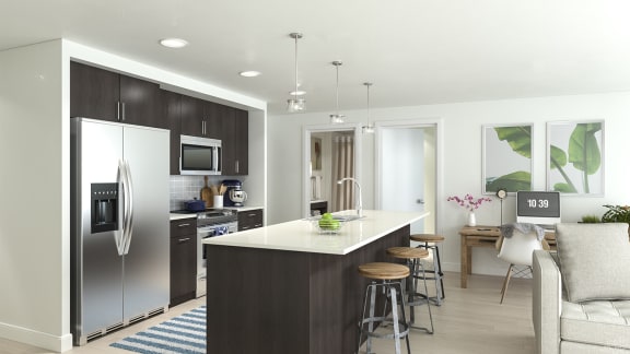 a kitchen with a center island and a stainless steel refrigerator