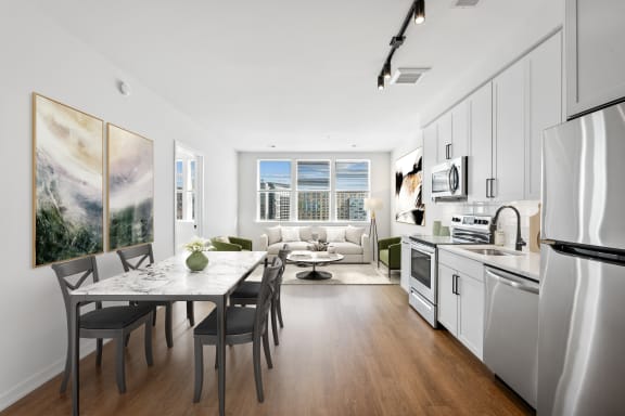a kitchen and living room with white cabinets and a table and chairs