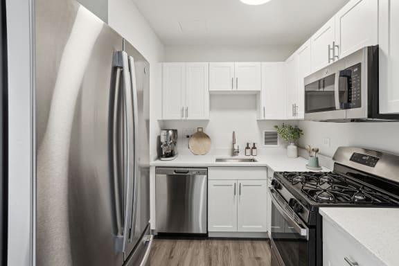 a kitchen with stainless steel appliances and white cabinets
