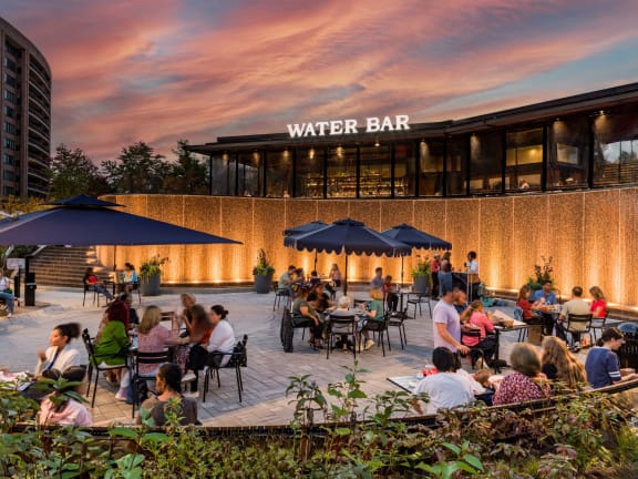 a group of people sitting at tables at a water bar
