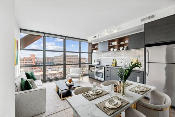 a living room with a kitchen and a large window