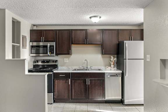 A kitchen with brown cabinets and a white refrigerator.