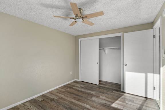 A room with a ceiling fan and a doorway leading to another room.