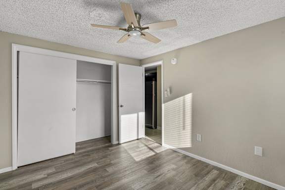 A room with a ceiling fan and a door leading to another room.