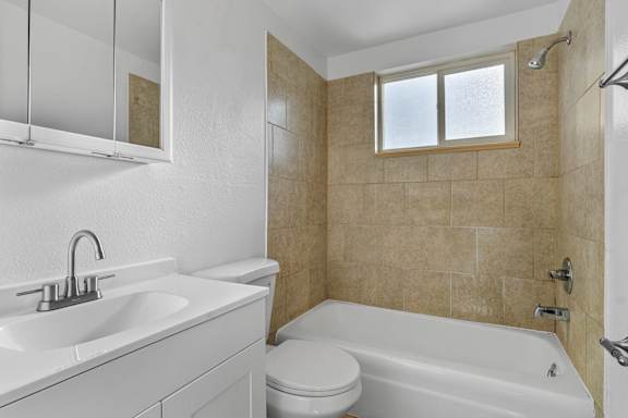A bathroom with a white sink and toilet.