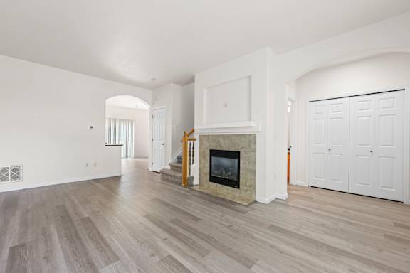 A living room with a fireplace and wood flooring.