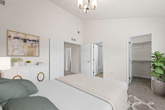 A bedroom with a bed, a couch, and a painting on the wall.