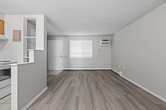 A kitchen area with a white oven and wooden flooring.