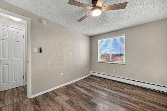 A room with a ceiling fan and a window with blinds.