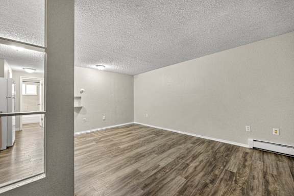 A room with wooden flooring and white walls.