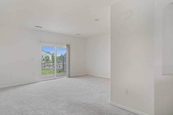 A white room with a sliding glass door leading to a patio.