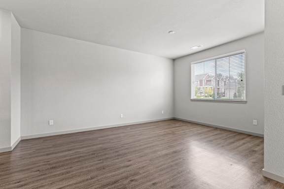 Living room of an apartment with wood flooring and a window at The Point at Biscay, Aurora, CO, Colorado, 80013