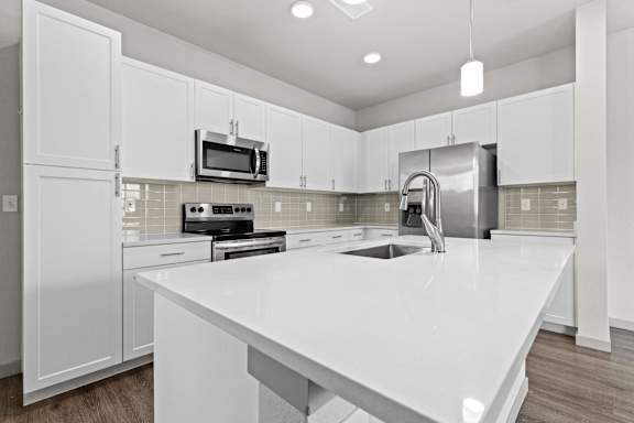 Large white kitchen with a white counter top at The Point at Biscay, Aurora, CO, Colorado