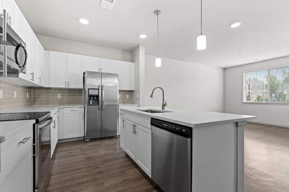 Renovated kitchen with white cabinets and stainless steel appliances at The Point at Biscay, Aurora, Colorado