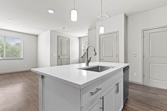 Open kitchen with a large white island with a sink at The Point at Biscay, Colorado