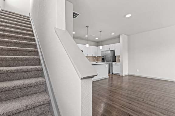 Renovated living room and staircase with a kitchen at The Point at Biscay, Aurora, CO, 80013