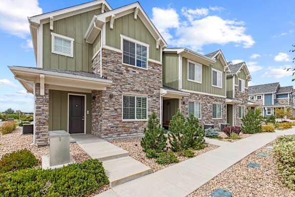 Exterior view of a house with stone and green siding at The Point at Biscay, Aurora, CO, Colorado, 80013