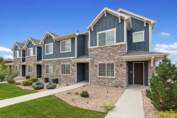 Exterior view of a house with stone and blue siding at The Point at Biscay, Aurora, CO, Colorado, 80013