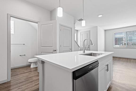White kitchen with a large white counter top and a sink at The Point at Biscay, Colorado, 80013