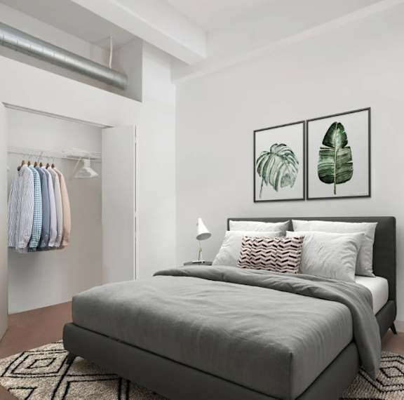 A bedroom with a large bed and two framed leaves on the wall.