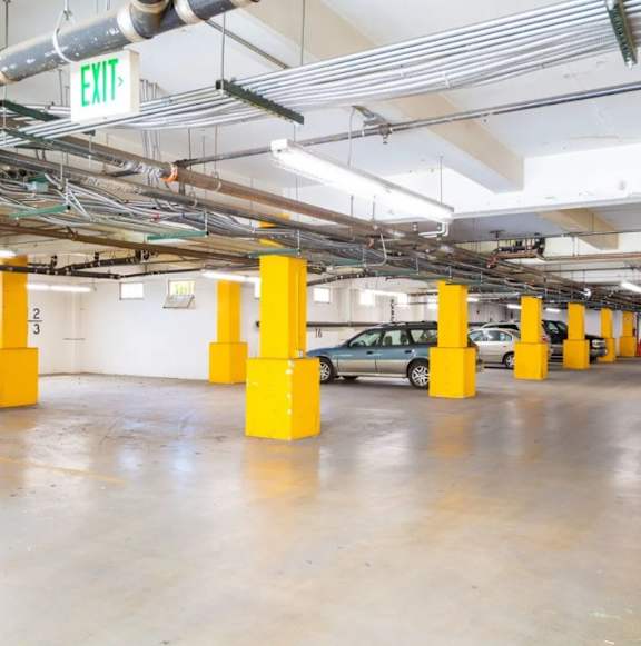 A parking garage with yellow poles and a sign that says "EXIT".