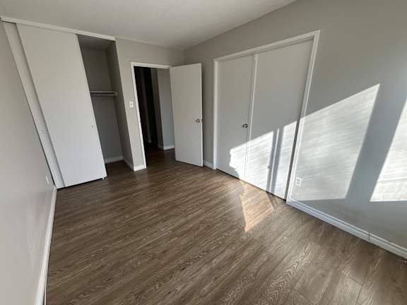 A room with wooden flooring and white walls.